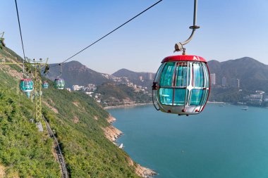 Teleferiğin güneşli manzarası ve okyanus kenarındaki eğlence parkı.