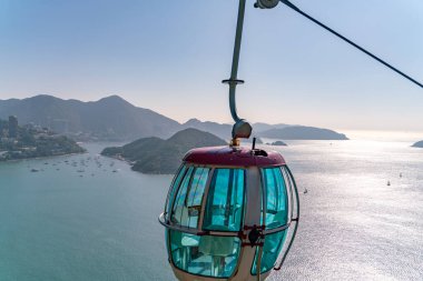 Teleferiğin güneşli manzarası ve okyanus kenarındaki eğlence parkı.