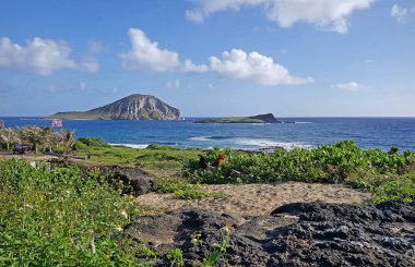 Oahu 'nun güney kıyısındaki pürüzlü lav kaya plajından Tavşan Adası manzarası