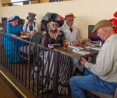 İyi giyimli son sınıflar Arizona Prescott Vadisi 'ndeki Arizona Downs Hipodromu' nda kadınlar gününde geçmişten görüntüler paylaşıyorlar. Fotoğraf 10 Ağustos 2019 'da çekildi..