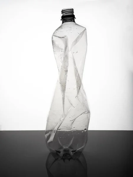 A large, empty crumpled soda bottle against a white background