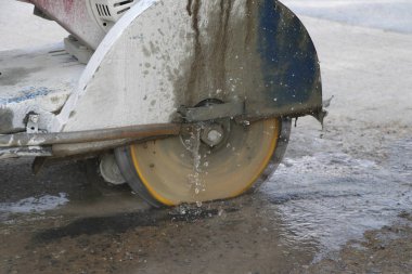 Beton kesme makinesi toz yayılması azaltmak için dökme su kullanarak beton zemin kesme.