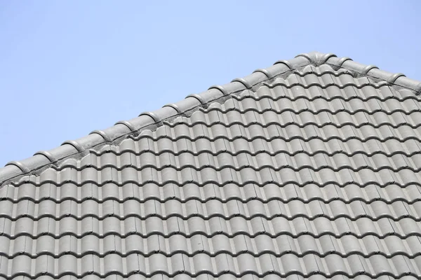 The roof tile with the sky background. The grey roman tile pattern.