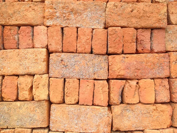 The orange brick that is stacked in a brick background. Stacked orange bricks.