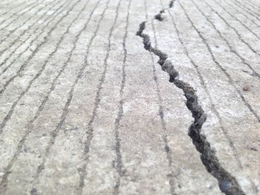 Çatlaklar, yarıklar, beton levhalar bu standart dışı inşaat neden olur. Yolun çatlağı.