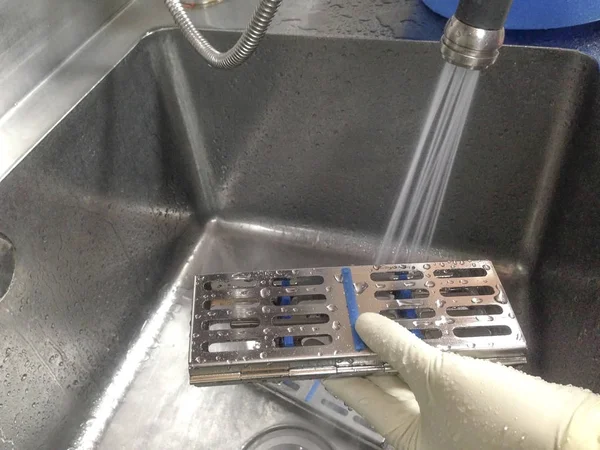 Tıbbi ekipmanları temizleme prosedürü. Lavaboda temiz tıbbi ekipman için su sebili. Su püskürtme ekipmanları.