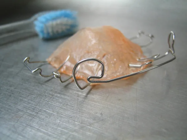 Ağız hijyeni için temizlenecek ortodontik aletin çıkarılması. Tedavinin sözel özelliklerinden oluşan özel plastik ve paslanmaz çelik telden yapılmış ortodontik Alet.  