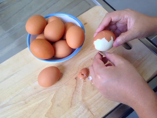 El Aktiviteleri mutfak masasında yumurta kabukları soyma vardır. Yemeye hazırlanmak için haşlanmış yumurtaları soyun.