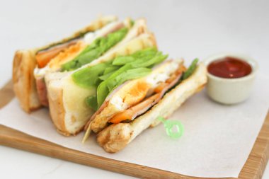 Yumurtalı sandviç ve ketçaplı yeşil meşe salatası..