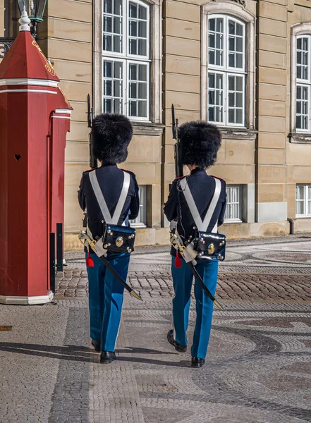 Two Guards on guard duty guarding Amalienborg or Royal Palace official residence of the Danish Royal Family in Copenhagen,