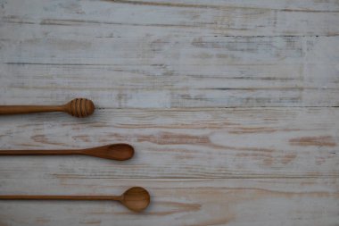 Ahşap masa arka planda Eko-dostu ahşap kaşık ve bal sopa. Çevre dostu mutfak malzemesi düz kopya alanı ile yatıyordu.