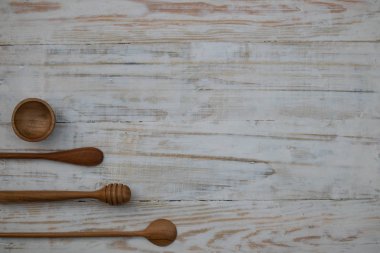 Ahşap masa arka planda çevre dostu ahşap kase, kaşık ve bal sopa. Çevre dostu sofra düz kopya alanı ile yatıyordu.