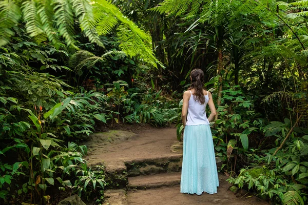 Молодий мандрівник жінка ходьбі в тропічному лісі, Убуд, Балі. Вид з спини. — стокове фото