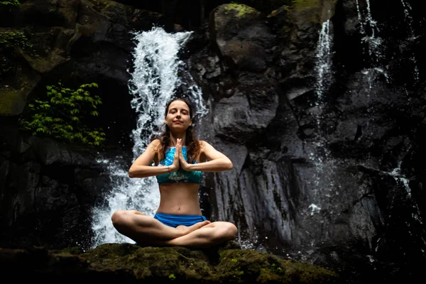 Молодая кавказская женщина медитирует, практикует йогу на водопаде в Убуде, Бали, Индонезия. Закрыть . — стоковое фото