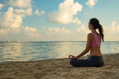 Yoga yaşam tarzı. Genç kadın meditasyon, plajda gyan mudra ile yoga ve pranayama pratik, Bali