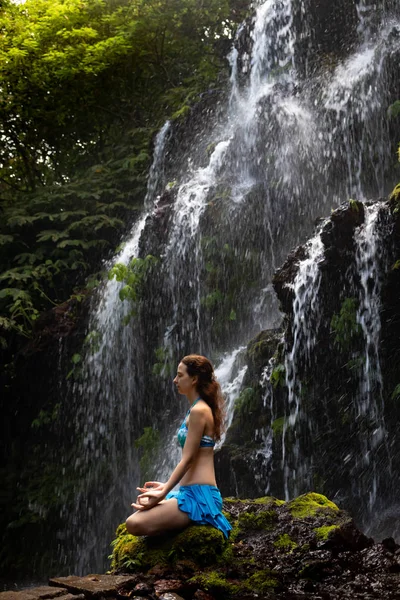 Giovane donna caucasica meditare, praticare yoga a cascata. Cascata di Banyu Wana Amertha Wanagiri, Bali, Indonesia . — Foto Stock