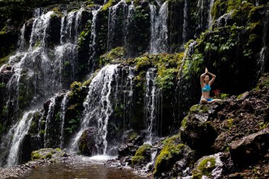 Genç Beyaz kadın meditasyon yapıyor, şelalede yoga yapıyor. Namaste mudra. Banyu Wana Amertha şelale Wanagiri, Bali, Endonezya. 