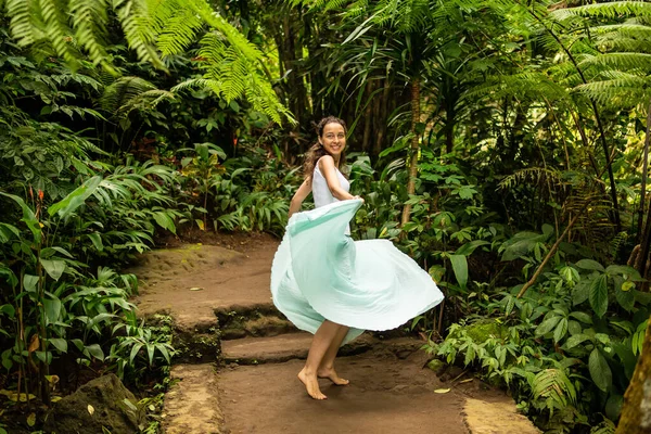 Fröhliche junge Frau tanzt auf Wanderweg im tropischen Wald. Lebensstil Reisen. Reise nach ubud, bali, Indonesien. — Stockfoto