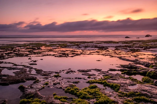 Paisaje marino. Puesta de sol en la playa. Marea baja del océano. Banner de fondo horizontal. Playa Nyang Nyang, Bali, Indonesia . — Foto de Stock