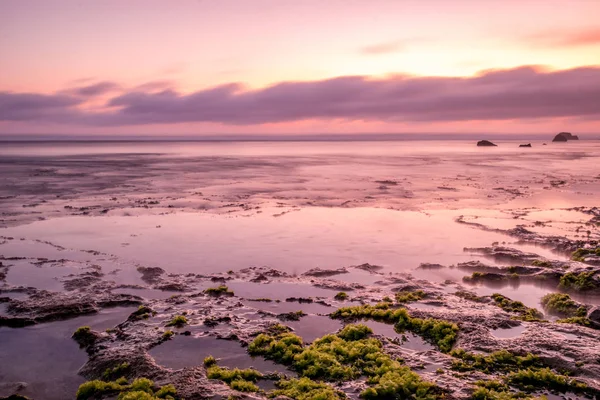 Paisaje marino. Puesta de sol en la playa. Marea baja del océano. Banner de fondo horizontal. Playa Nyang Nyang, Bali, Indonesia. Velocidad de obturación lenta, fotografía en movimiento . — Foto de Stock