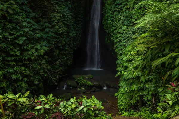 Waterfall landscape. Beautiful hidden Leke Leke waterfall in Bali. Tropical scenery. Waterfall in tropical rainforest. Slow shutter speed, motion photography. Horizontal layout.