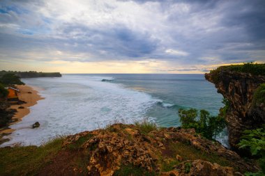 Nefes kesici deniz manzarası. Bali 'deki Balangan uçurumundan muhteşem bir manzara. Gün batımı zamanı. Mavi saat. Hareket köpüklü okyanus. Arka plan için su manzarası. Doğa konsepti. Yumuşak odaklanma. Yavaş deklanşör hızı.