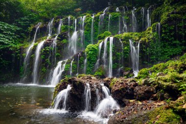Tropik bir manzara. Yağmur ormanlarında saklı güzel bir şelale. Macera ve seyahat konsepti. Doğa geçmişi. Yavaş deklanşör hızı, hareket fotoğrafçılığı. Banyu Wana Amertha Şelalesi Bali, Endonezya