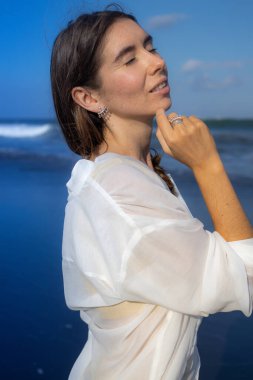 Mücevherli güzel bir kadının portresini yakından çek. Kapalı gözler. Beyaz kadın gün ışığının tadını çıkarıyor. Güzellik ve moda konsepti. Bali, Endonezya