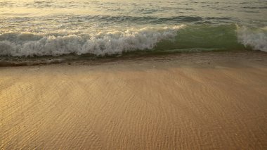 Manzaralı deniz manzarası. Kumsalda köpüklü dalgalar. Gün batımı zamanı. Arka plan için su manzarası. Seçilmiş yumuşak sanat odağı. Suya ve ıslak kuma güneş ışığı yansıması. Uzayı kopyala Balangan Sahili, Bali, Endonezya