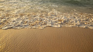 Manzaralı deniz manzarası. Kumsalda köpüklü dalgalar. Gün batımı zamanı. Arka plan için su manzarası. Seçilmiş yumuşak sanat odağı. Suya ve ıslak kuma güneş ışığı yansıması. Uzayı kopyala Balangan Sahili, Bali, Endonezya