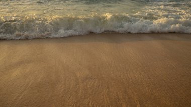Manzaralı deniz manzarası. Kumsalda köpüklü dalgalar. Gün batımı zamanı. Arka plan için su manzarası. Seçilmiş yumuşak sanat odağı. Suya ve ıslak kuma güneş ışığı yansıması. Uzayı kopyala Balangan Sahili, Bali, Endonezya