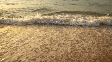 Manzaralı deniz manzarası. Kumsalda köpüklü dalgalar. Gün batımı zamanı. Arka plan için su manzarası. Seçilmiş yumuşak sanat odağı. Suya ve ıslak kuma güneş ışığı yansıması. Uzayı kopyala Balangan Sahili, Bali, Endonezya