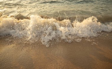 Manzaralı deniz manzarası. Kumsalda dalgalar savruluyor. Gün batımı zamanı. Arka plan için su manzarası. Seçilmiş yumuşak sanat odağı. Suya ve ıslak kuma güneş ışığı yansıması. Uzayı kopyala Balangan Sahili, Bali, Endonezya