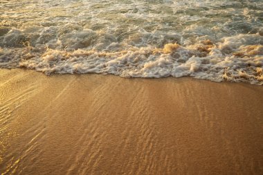Manzaralı deniz manzarası. Kumsalda köpüklü dalgalar. Gün batımı zamanı. Arka plan için su manzarası. Seçilmiş yumuşak sanat odağı. Suya ve ıslak kuma güneş ışığı yansıması. Uzayı kopyala Balangan Sahili, Bali, Endonezya