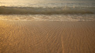 Manzaralı deniz manzarası. Kumsalda köpüklü dalgalar. Gün batımı zamanı. Arka plan için su manzarası. Seçilmiş yumuşak sanat odağı. Suya ve ıslak kuma güneş ışığı yansıması. Balangan Sahili, Bali, Endonezya