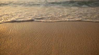 Manzaralı deniz manzarası. Kumsalda köpüklü dalgalar. Gün batımı zamanı. Arka plan için su manzarası. Seçilmiş yumuşak sanat odağı. Suya ve ıslak kuma güneş ışığı yansıması. Uzayı kopyala Balangan Sahili, Bali, Endonezya