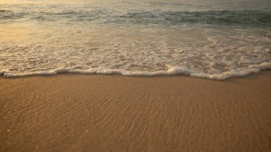 Manzaralı deniz manzarası. Kumsalda köpüklü dalgalar. Gün batımı zamanı. Arka plan için su manzarası. Seçilmiş yumuşak sanat odağı. Suya ve ıslak kuma güneş ışığı yansıması. Uzayı kopyala Balangan Sahili, Bali, Endonezya