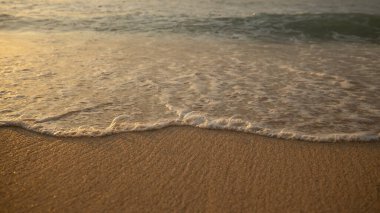 Manzaralı deniz manzarası. Kumsalda köpüklü dalgalar. Gün batımı zamanı. Arka plan için su manzarası. Seçilmiş yumuşak sanat odağı. Suya ve ıslak kuma güneş ışığı yansıması. Balangan Sahili, Bali, Endonezya