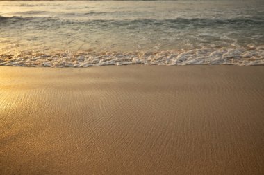Manzaralı deniz manzarası. Kumsalda köpüklü dalgalar. Gün batımı zamanı. Arka plan için su manzarası. Seçilmiş yumuşak sanat odağı. Suya ve ıslak kuma güneş ışığı yansıması. Uzayı kopyala Balangan Sahili, Bali, Endonezya
