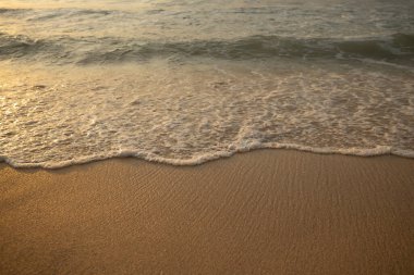 Manzaralı deniz manzarası. Kumsalda köpüklü dalgalar. Gün batımı zamanı. Arka plan için su manzarası. Seçilmiş yumuşak sanat odağı. Suya ve ıslak kuma güneş ışığı yansıması. Balangan Sahili, Bali, Endonezya