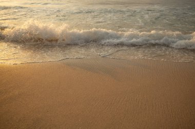 Manzaralı deniz manzarası. Kumsalda köpüklü dalgalar. Gün batımı zamanı. Arka plan için su manzarası. Seçilmiş yumuşak sanat odağı. Suya ve ıslak kuma güneş ışığı yansıması. Balangan Sahili, Bali, Endonezya