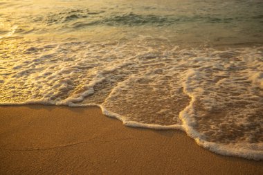 Manzaralı deniz manzarası. Kumsalda köpüklü dalgalar. Gün batımı zamanı. Arka plan için su manzarası. Seçilmiş yumuşak sanat odağı. Suya ve ıslak kuma güneş ışığı yansıması. Balangan Sahili, Bali, Endonezya