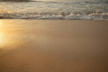 Manzaralı deniz manzarası. Kumsalda köpüklü dalgalar. Gün batımı zamanı. Arka plan için su manzarası. Seçilmiş yumuşak sanat odağı. Suya ve ıslak kuma güneş ışığı yansıması. Balangan Sahili, Bali, Endonezya