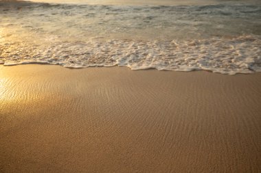 Manzaralı deniz manzarası. Kumsalda köpüklü dalgalar. Gün batımı zamanı. Arka plan için su manzarası. Seçilmiş yumuşak sanat odağı. Suya ve ıslak kuma güneş ışığı yansıması. Balangan Sahili, Bali, Endonezya