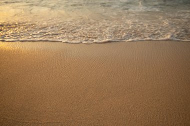 Manzaralı deniz manzarası. Kumsalda köpüklü dalgalar. Gün batımı zamanı. Arka plan için su manzarası. Seçilmiş yumuşak sanat odağı. Suya ve ıslak kuma güneş ışığı yansıması. Balangan Sahili, Bali, Endonezya