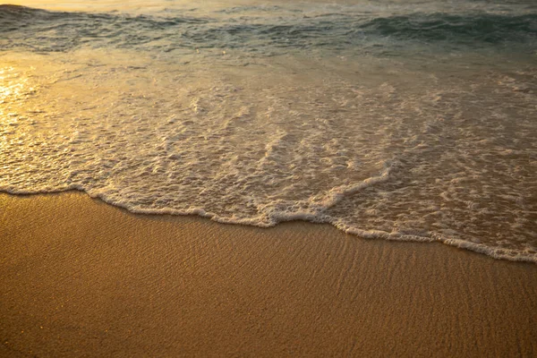 Manzaralı deniz manzarası. Kumsalda köpüklü dalgalar. Gün batımı zamanı. Arka plan için su manzarası. Seçilmiş yumuşak sanat odağı. Suya ve ıslak kuma güneş ışığı yansıması. Balangan Sahili, Bali, Endonezya