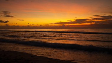 Gün batımında plaj. Deniz Burnu. Parlak güneş ışığı. Güneş ufukta görünüyor. Manzaralı. Gün batımı altın saati. Suda güneş ışığı yansıması. Muhteşem bir manzara. Balangan Sahili, Bali, Endonezya 