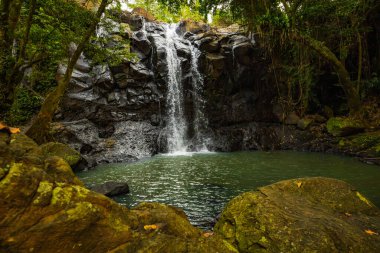 Tropik bir manzara. Yağmur ormanlarında saklı güzel bir şelale. Büyük taşlı ön plan. Macera konsepti. Doğa geçmişi. Hızlı deklanşör hızı. Sing Sing Angin Şelalesi, Bali, Endonezya