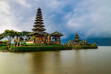 Bali adasındaki Pura Ulun Danu Bratan tapınağı. Güzel bale tapınağı. Bali 'nin simgesi. Bulutlu gökyüzü. Su yansıması. Kapama hızı yavaş. Bratan Gölü, Bali, Endonezya