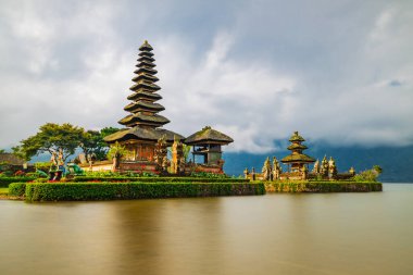 Bali adasındaki Pura Ulun Danu Bratan tapınağı. Güzel bale tapınağı. Bali 'nin simgesi. Bulutlu gökyüzü. Su yansıması. Kapama hızı yavaş. Bratan Gölü, Bali, Endonezya